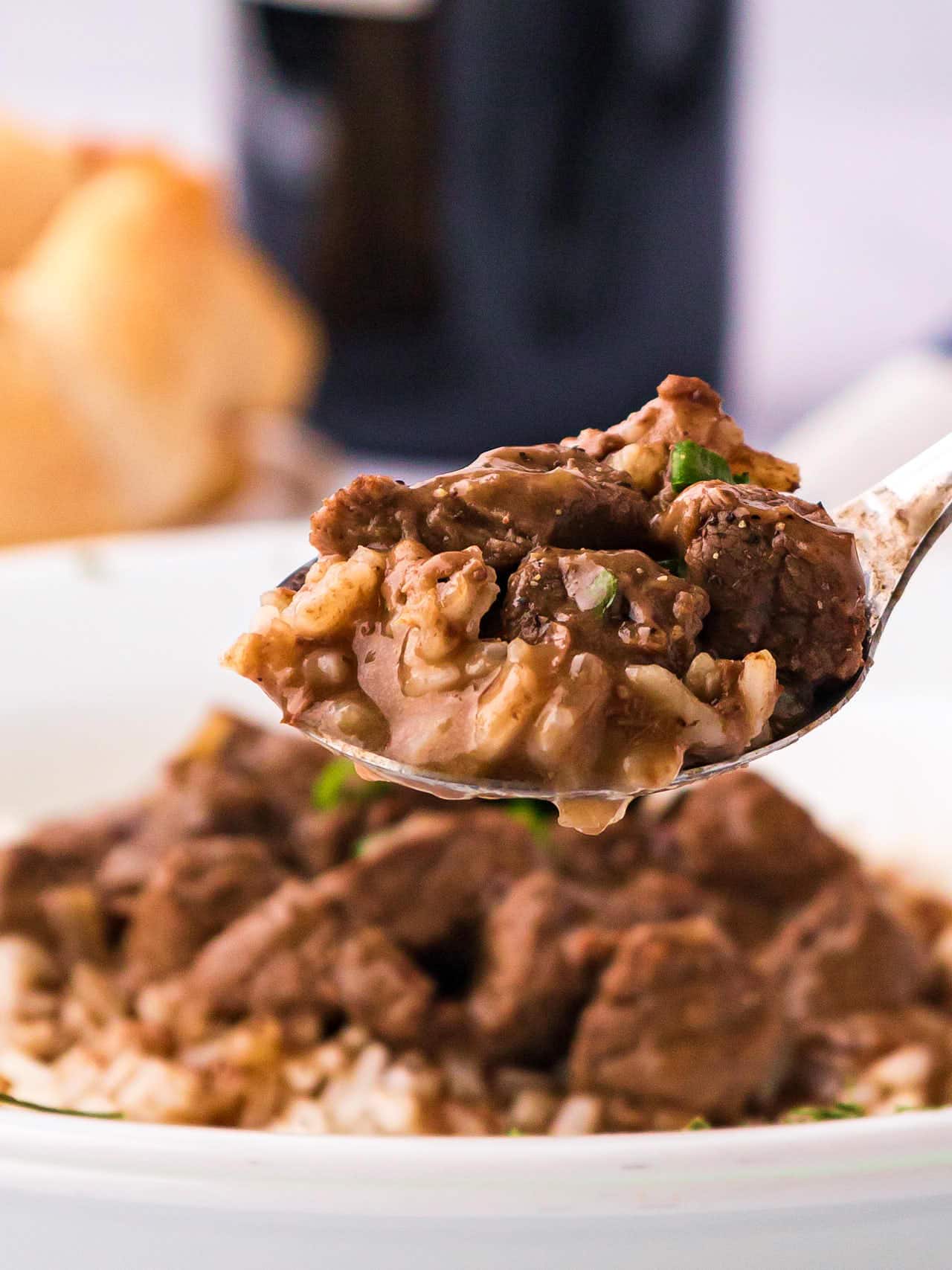 A forkful of rice and steak.