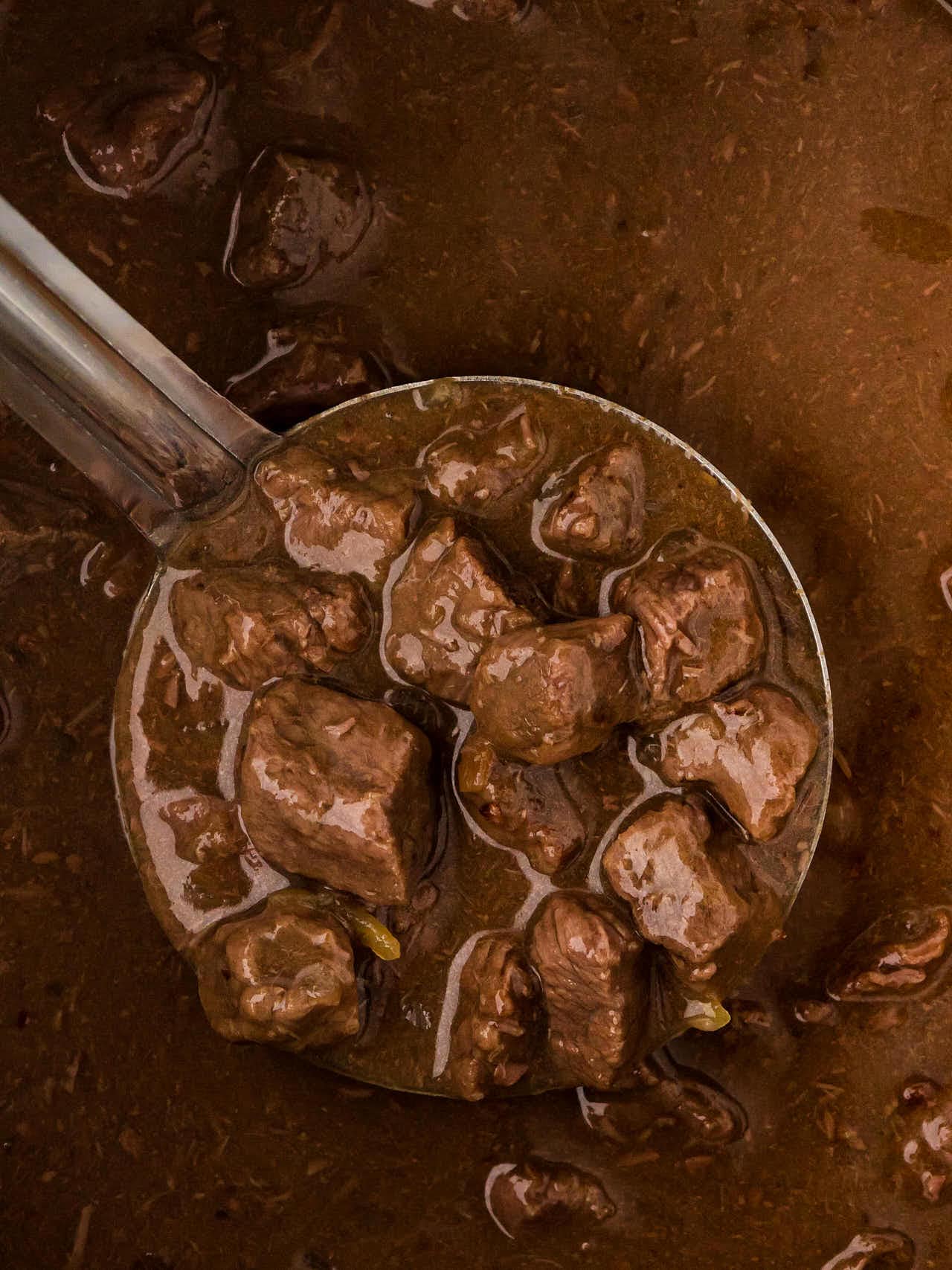 A ladle of steak and sauce. 