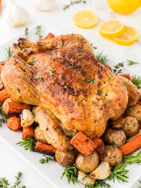 Roasted Chicken served over roast potatoes and carrots.