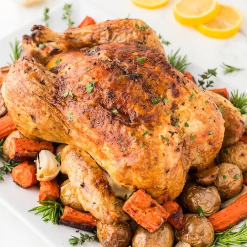 Roasted Chicken served over roast potatoes and carrots.