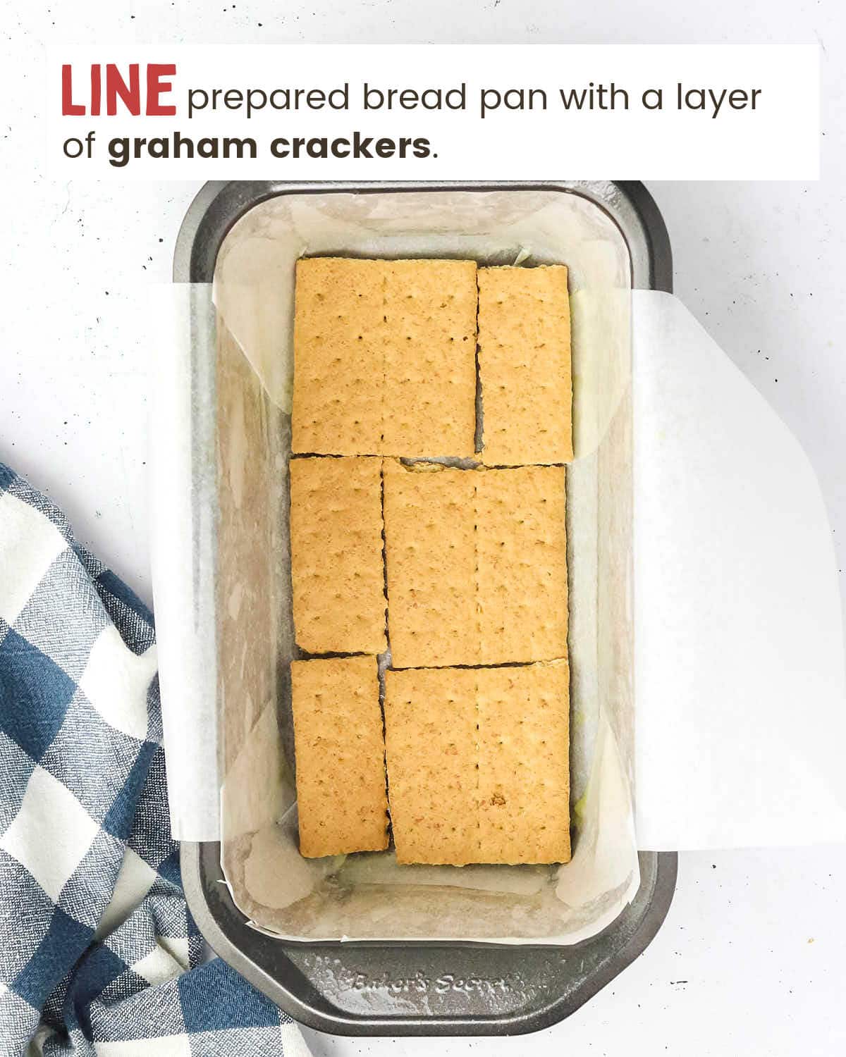 Graham crackers in a single layer in the bottom of a bread pan lined with parchment paper. 