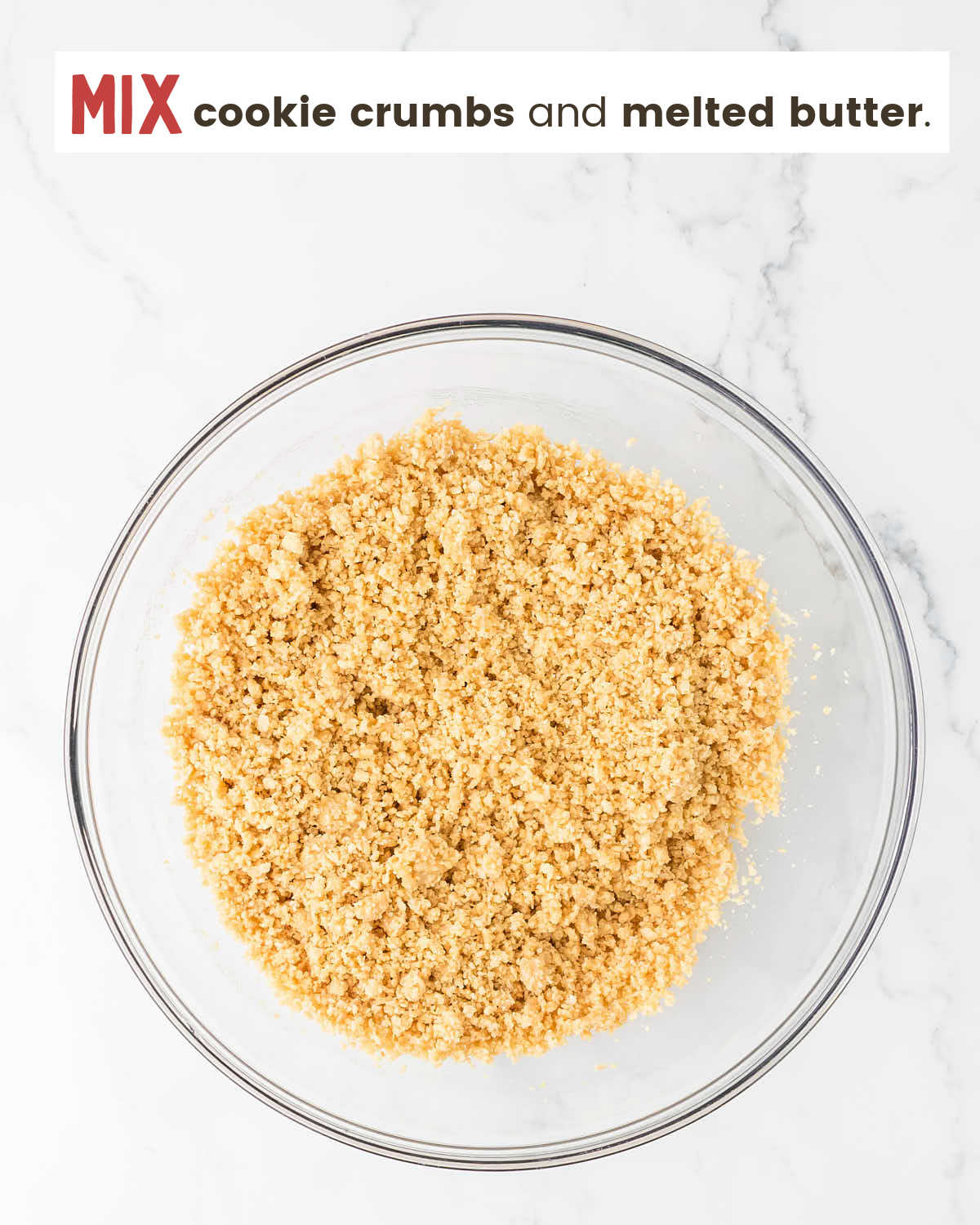 Golden Oreo cookie crumbs mixed with melted butter in a bowl. 