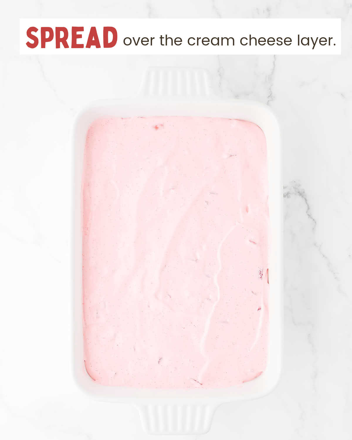 Strawberry whipped topping layer in a baking dish.