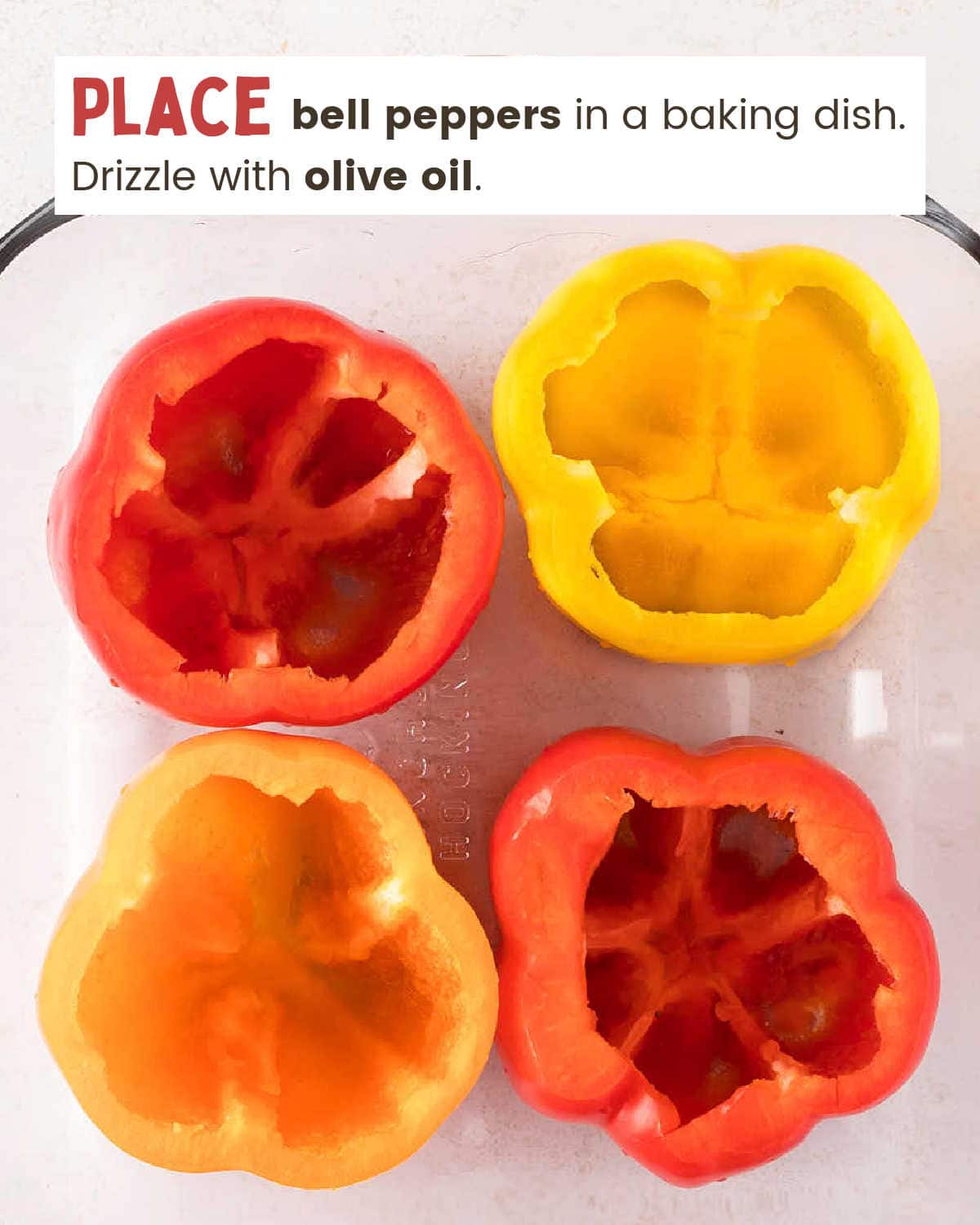 Cleaned and cored bell peppers in a glass baking dish.