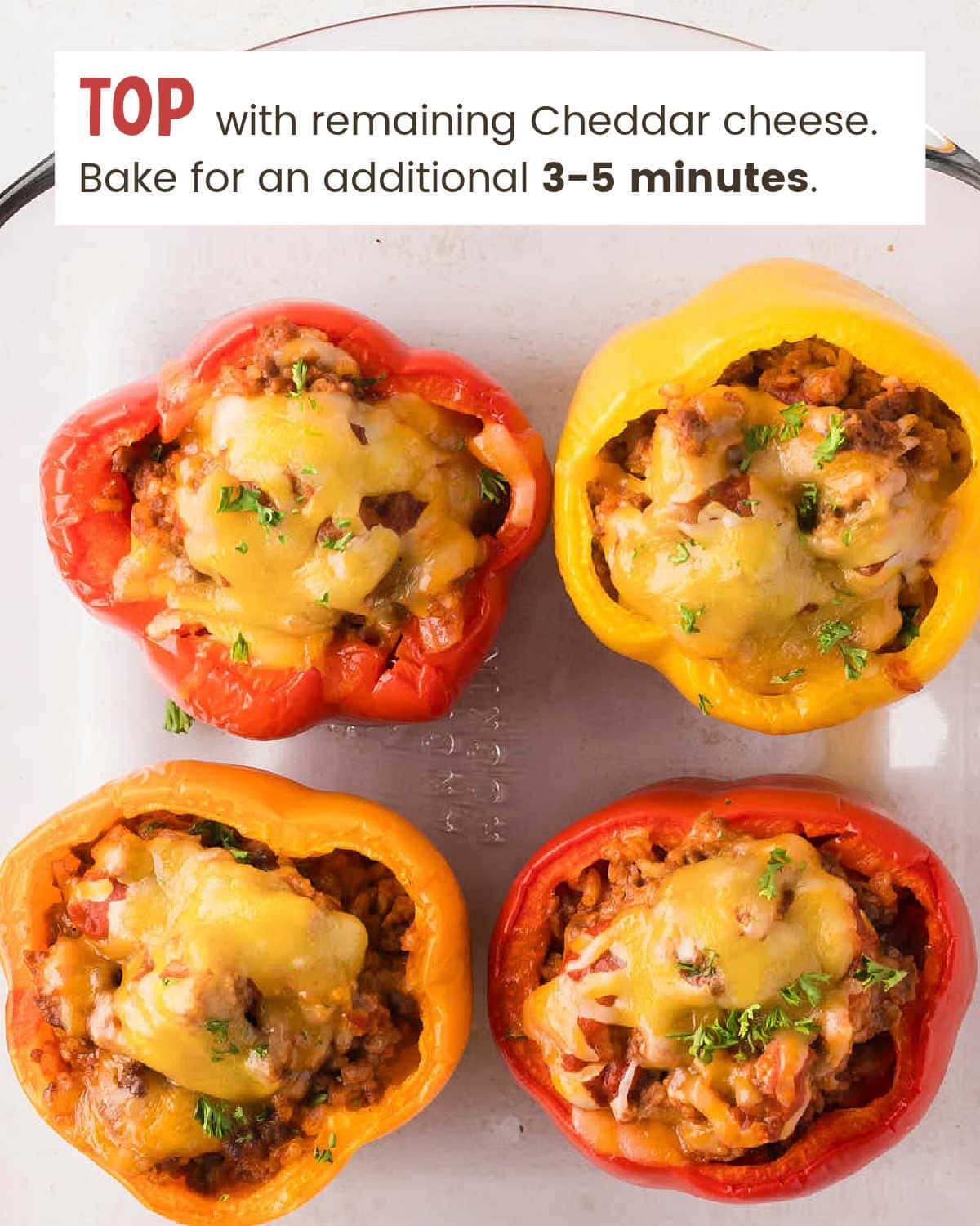 Stuffed bell peppers topped with melted cheese in a baking dish.