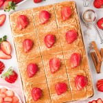Sliced Tres Leches Cake garnished with fresh strawberries.