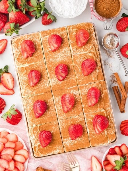 Sliced Tres Leches Cake garnished with fresh strawberries.