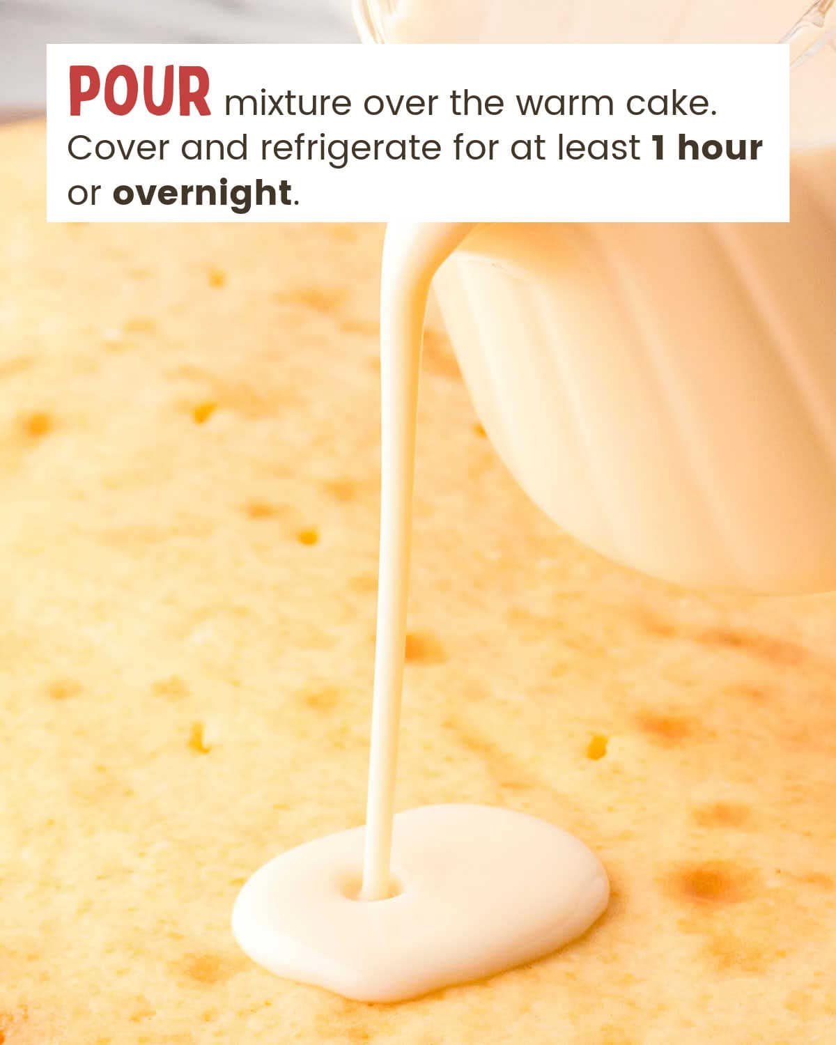 Milk mixture poured out of a pitcher onto a cake.
