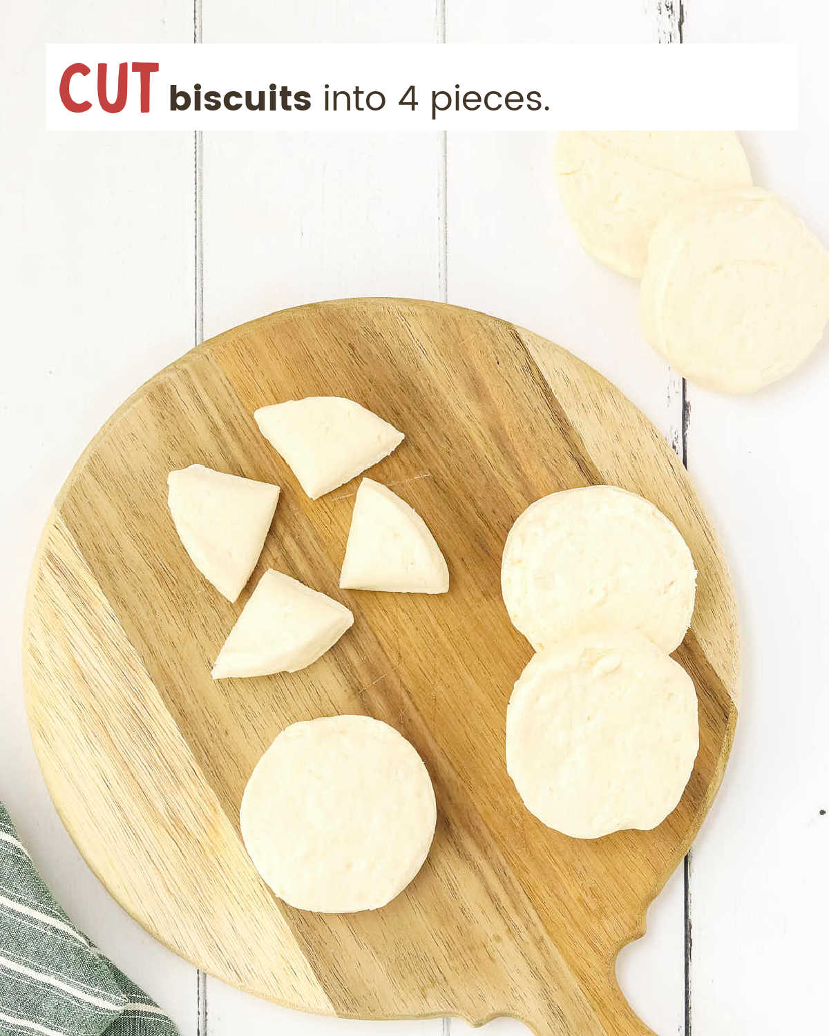 Biscuit rounds on and near a cutting board with one biscuit cut into four pieces.