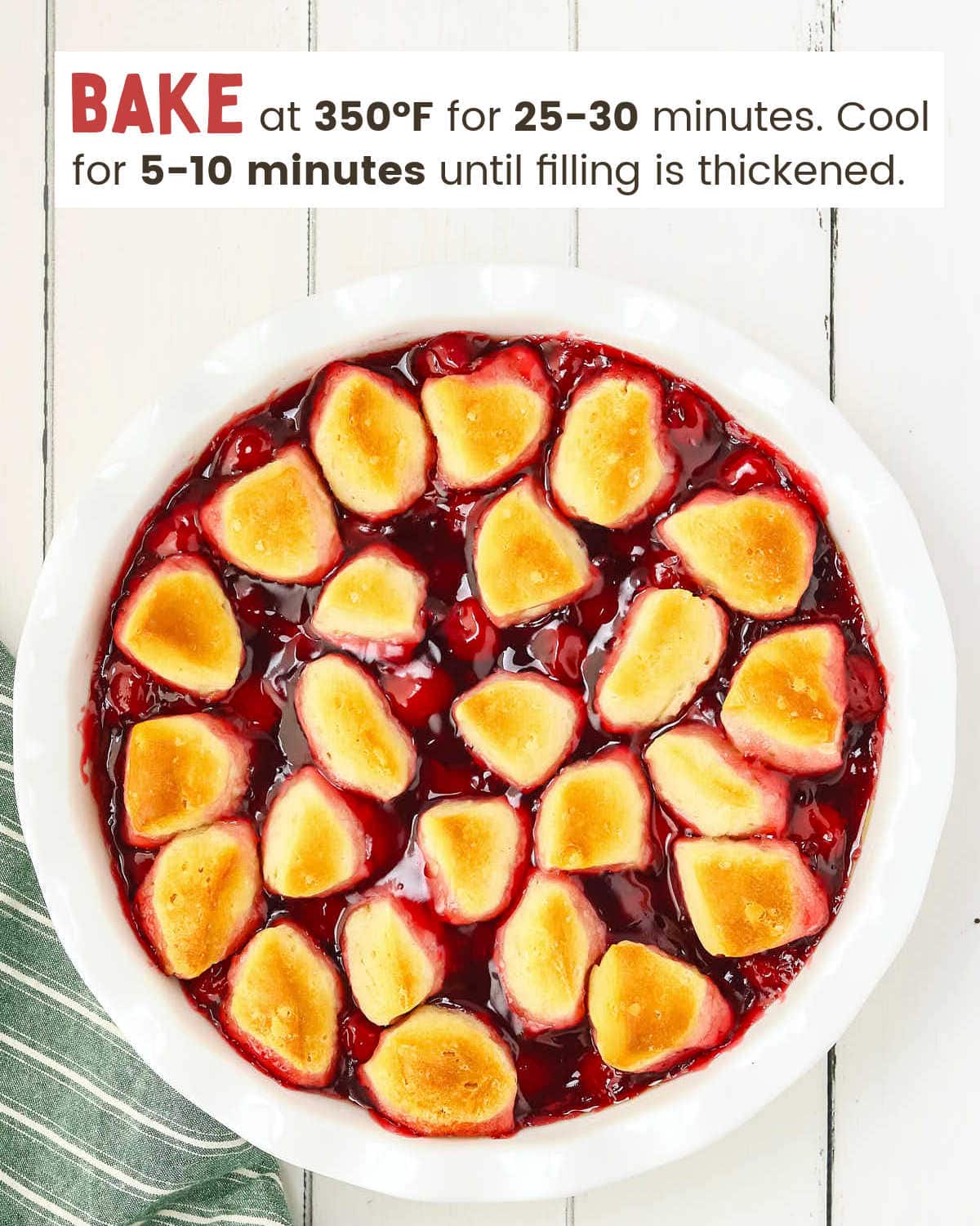 Baked cherry pie filling with biscuit pieces in a white pie plate.