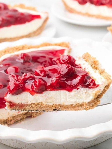 A slice of Cherry Cream Cheese Pie on a cake lifter.