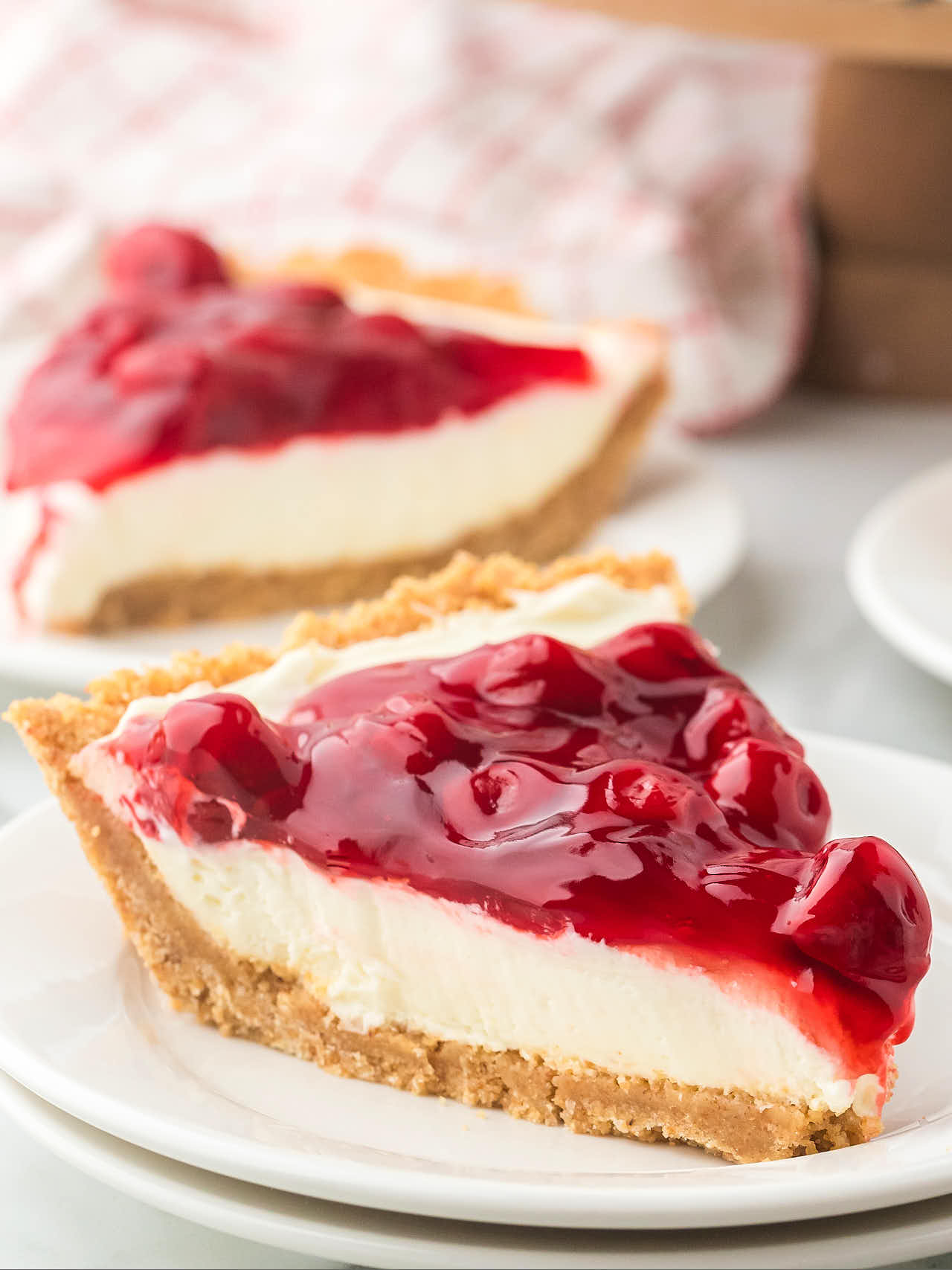 Closeup of a slice of no-bake Cherry Pie on a white plate.