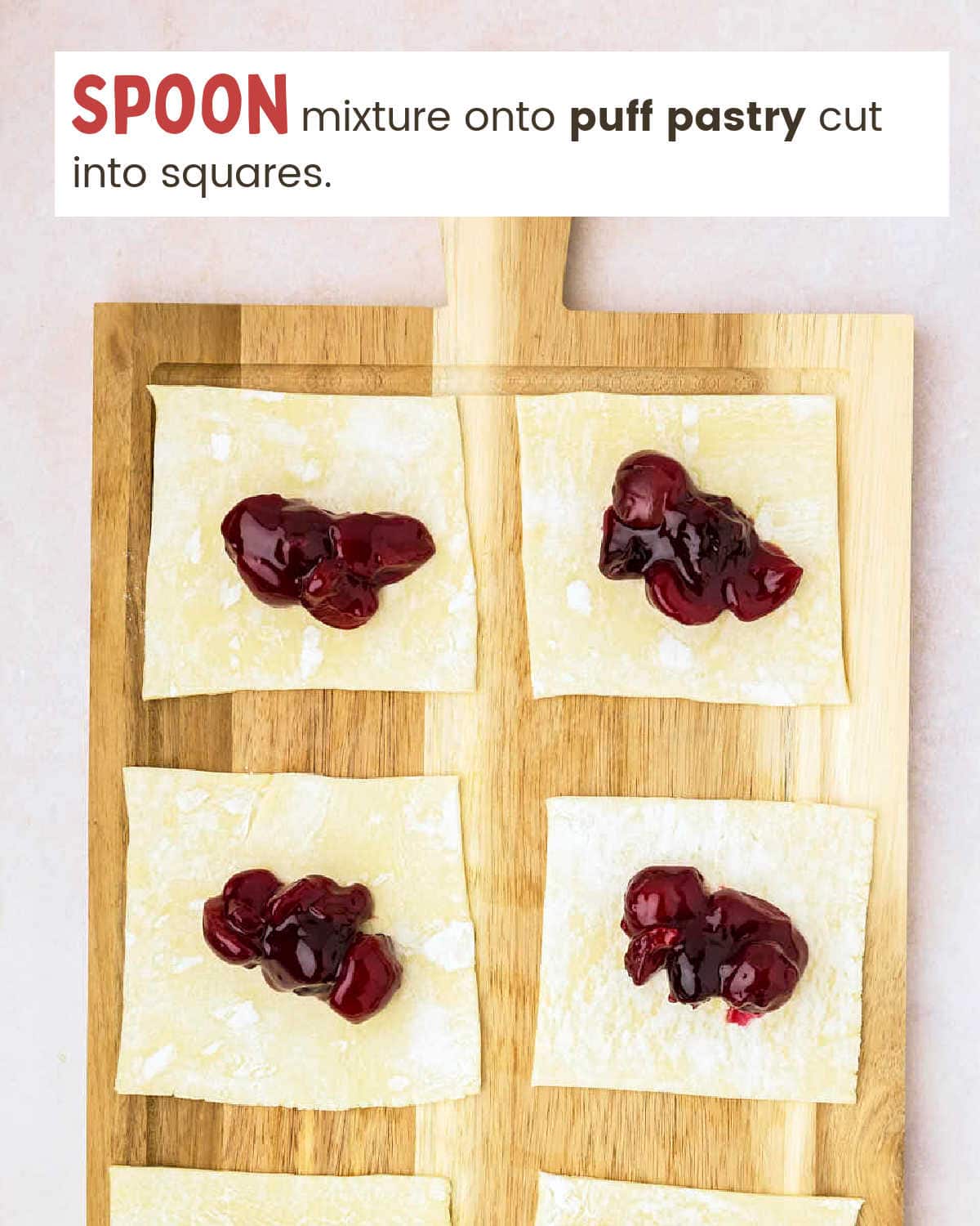 Cherry mixture in center of puff pastry squares on a cutting board.