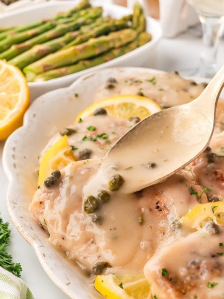 Drizzling sauce over the Chicken Piccata.
