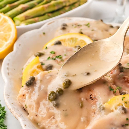 Drizzling sauce over the Chicken Piccata.