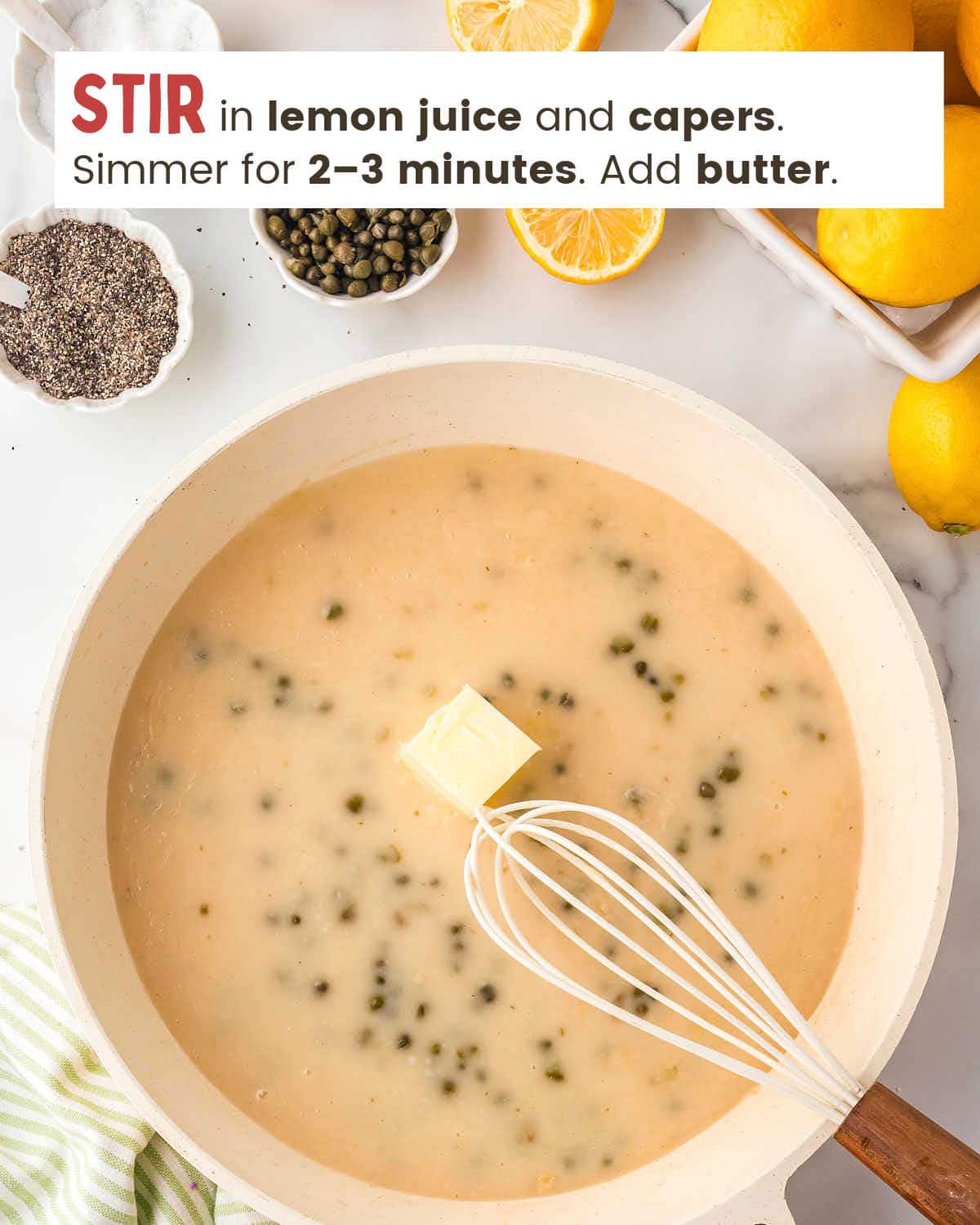 A whisk in a skillet with chicken broth, capers, lemon juice, and a pat of butter.
