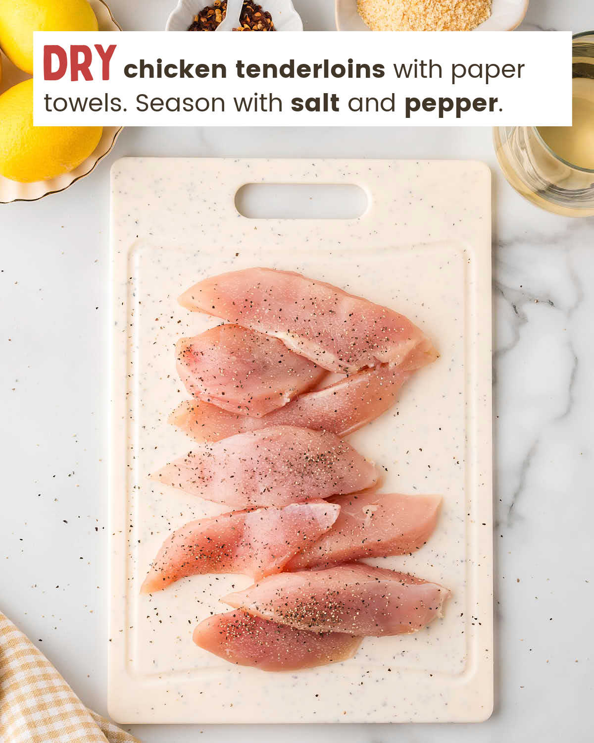 Chicken tenderloins on a cutting board seasoned with salt and pepper. 