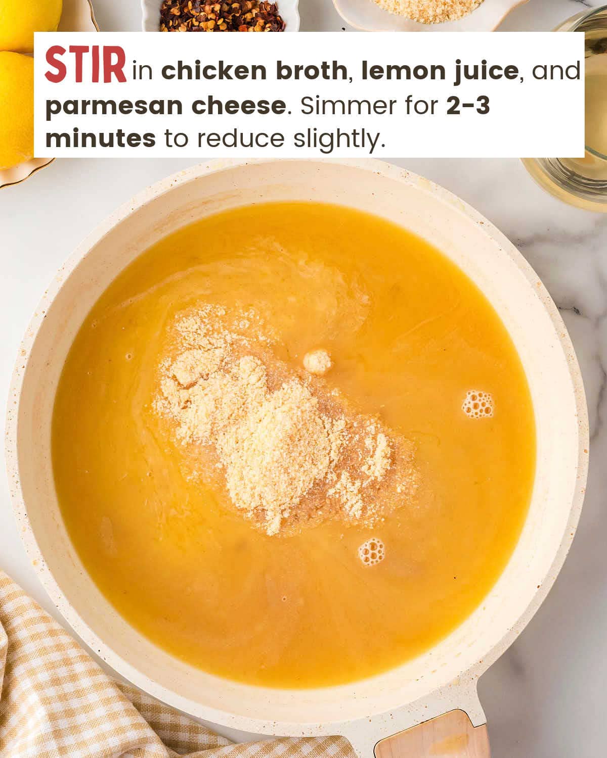 Chicken broth, lemon juice, and parmesan cheese in a skillet.