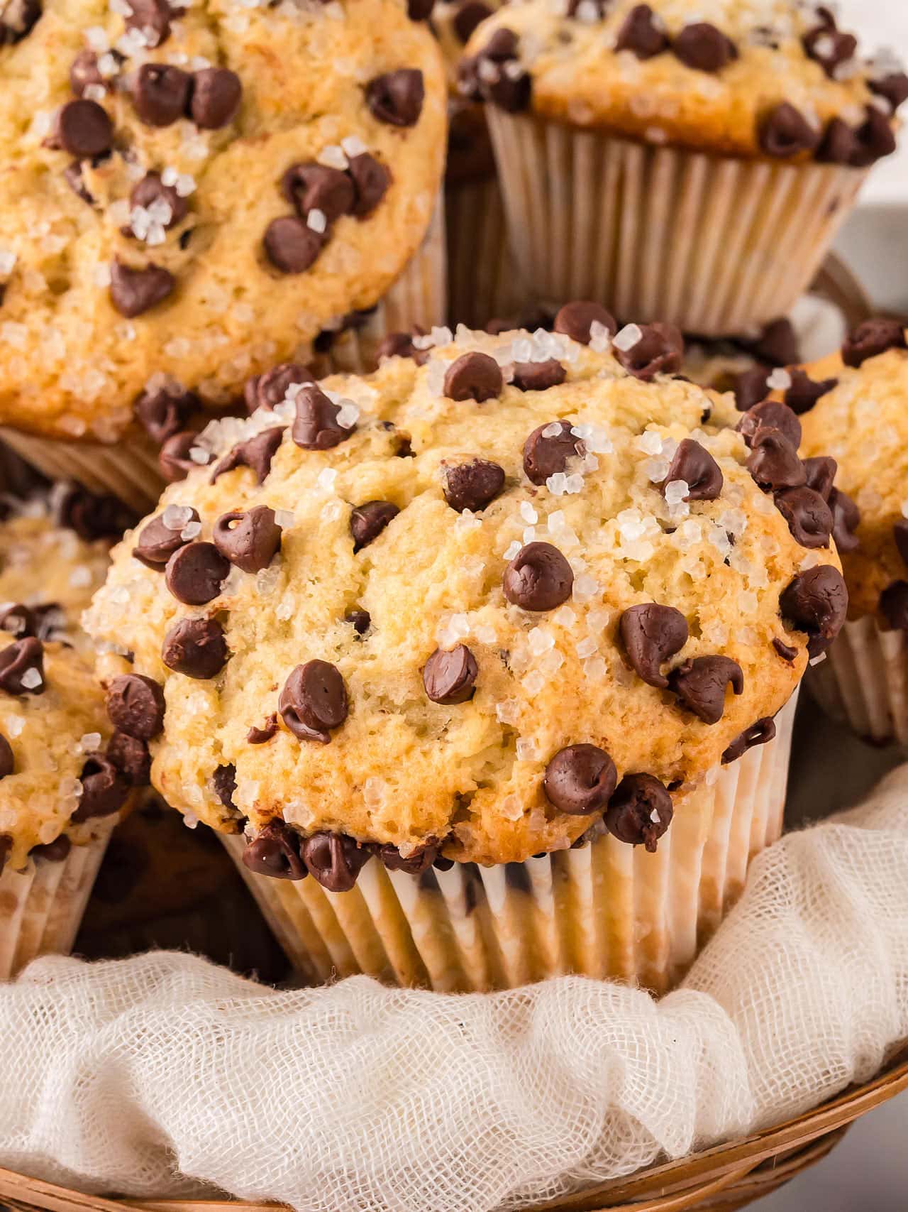 Closeup of freshly baked Chocolate Chip Muffins served in a basket.