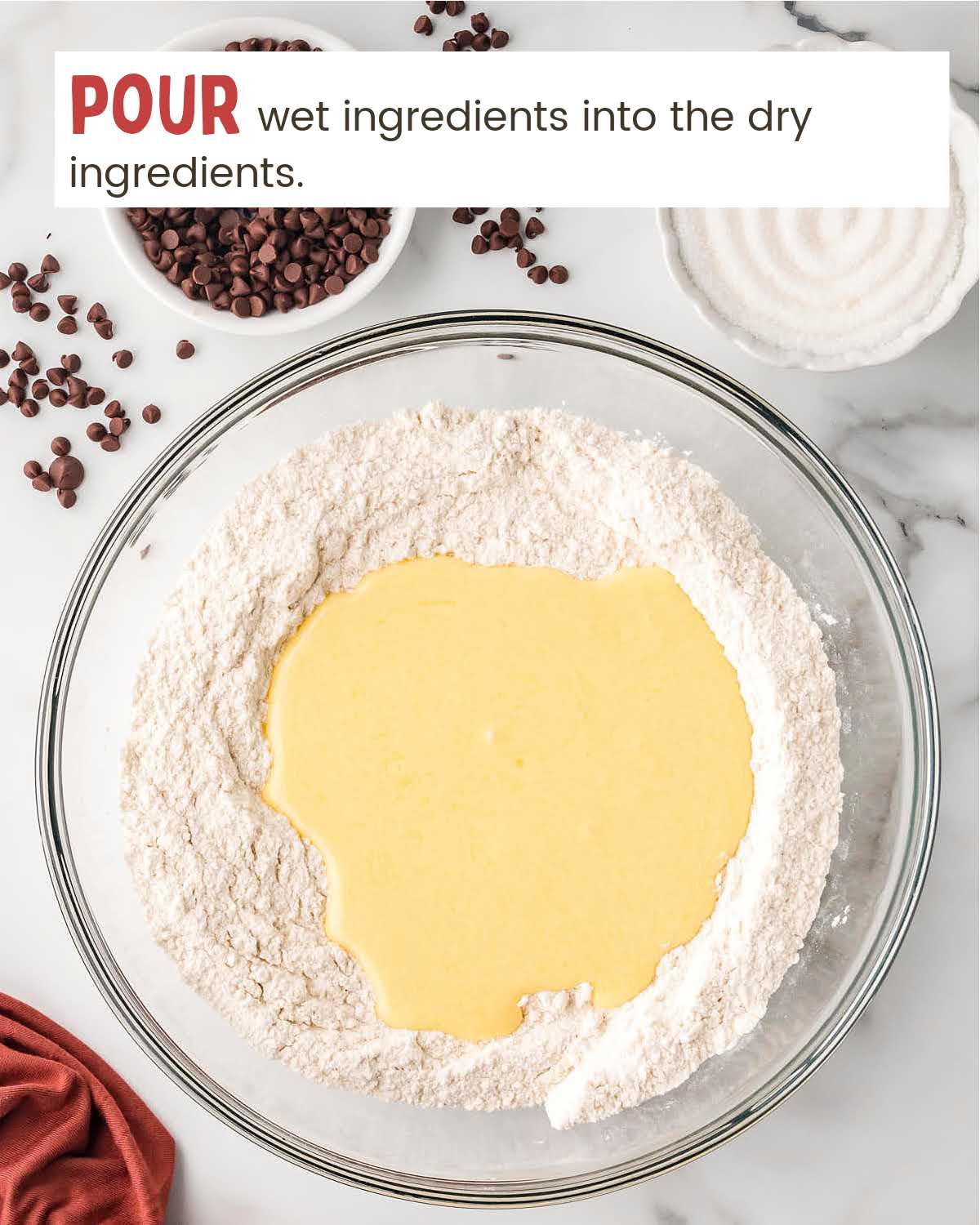 Wet ingredients for muffins on top of dry ingredients in a mixing bowl.