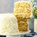 Lifting a slice of Coconut Cake with a cake lifter off a plate.