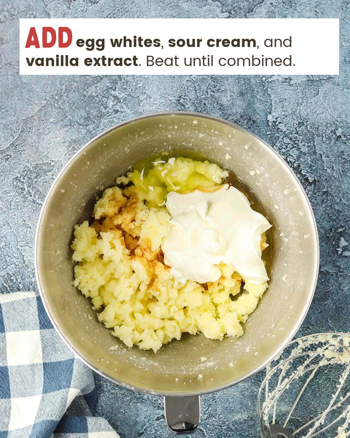 Egg whites, sour cream, and vanilla added to in a mixing bowl with creamed butter.