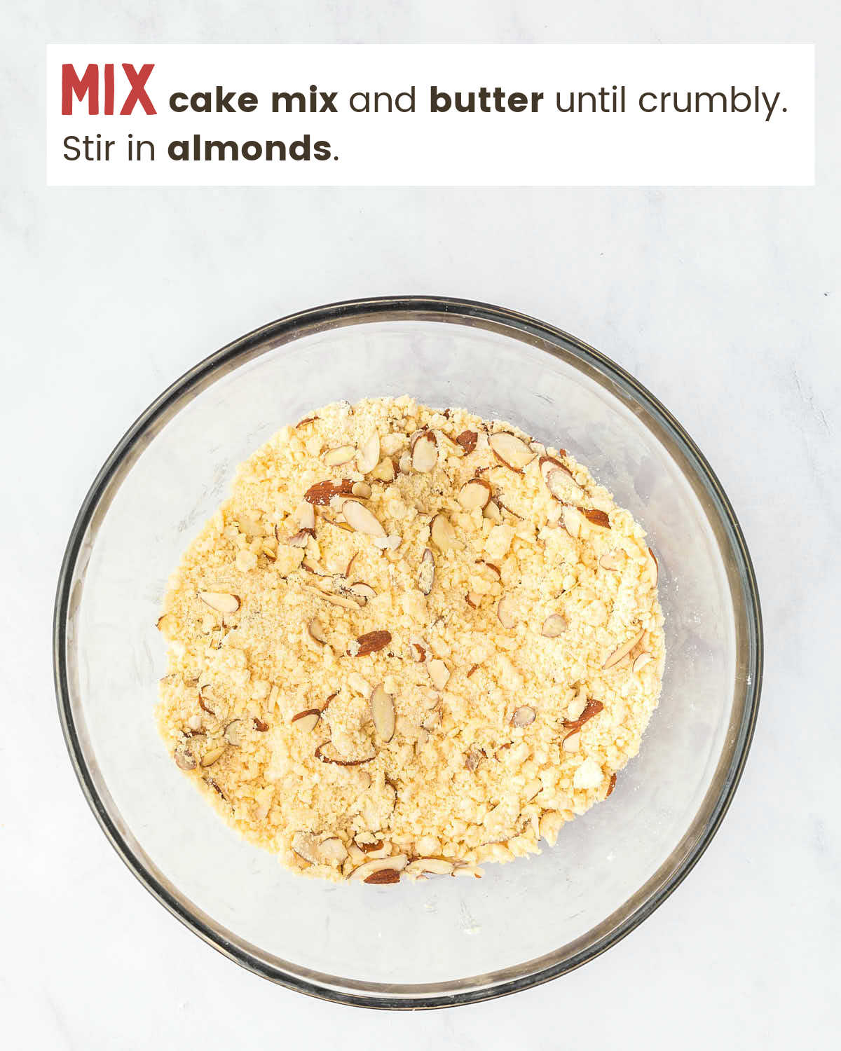Cake mix mixed with butter and almonds in a mixing bowl.