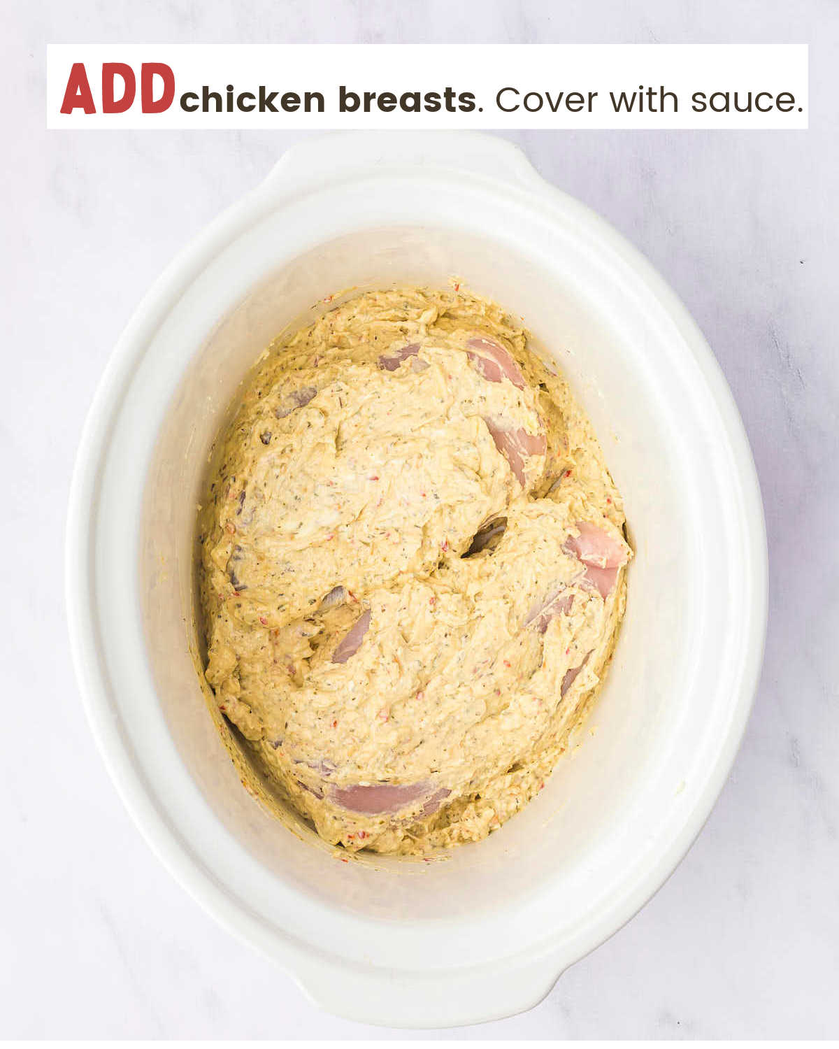 Chicken breasts covered with garlic parmesan sauce in a Crock-Pot.