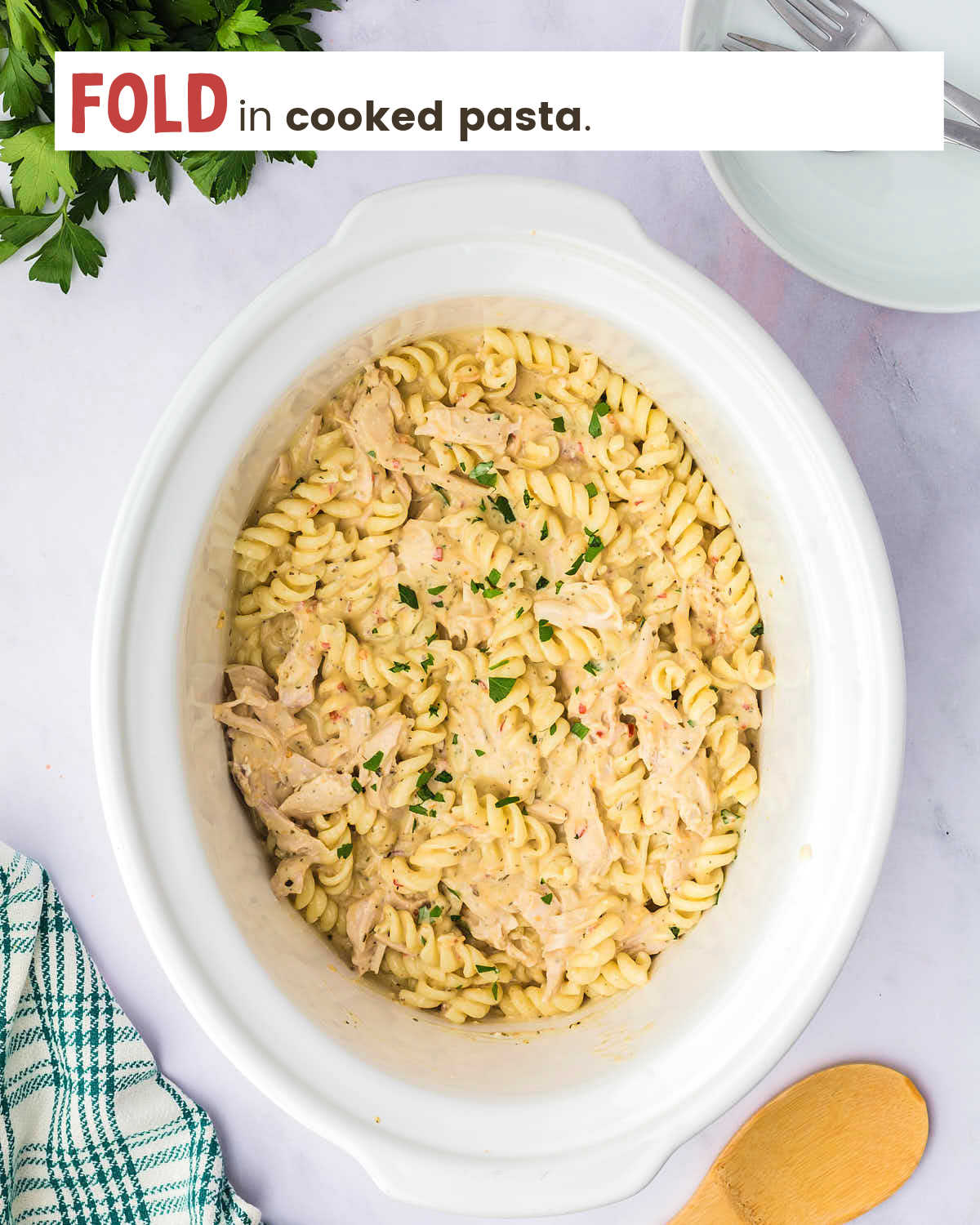 Chicken and pasta covered with garlic parmesan sauce in a Crock-Pot.