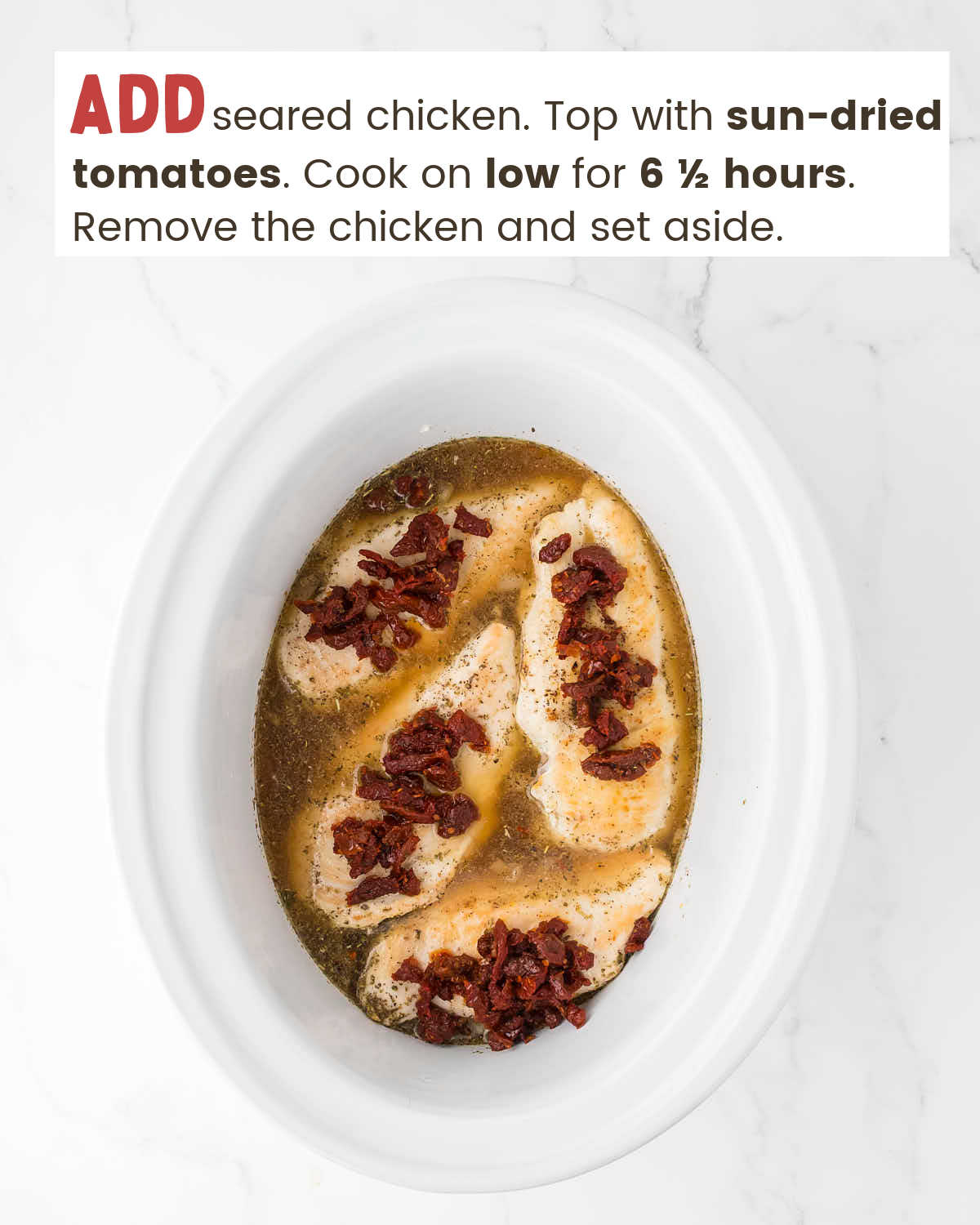 Chicken breasts topped with sun-dried tomatoes surrounded by chicken broth in a slow cooker.