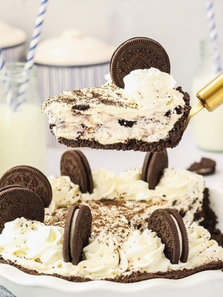 A slice Oreo Pie on a cake lifter hovering over the pie dish.