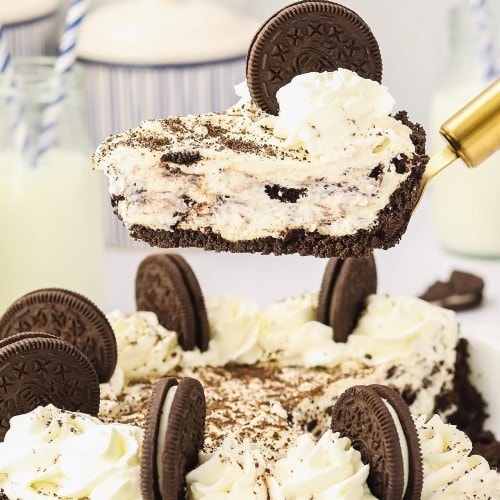 A slice Oreo Pie on a cake lifter hovering over the pie dish.