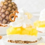 A slice of Pineapple Pretzel Salad topped with whipped cream.