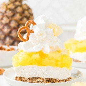 A slice of Pineapple Pretzel Salad topped with whipped cream.