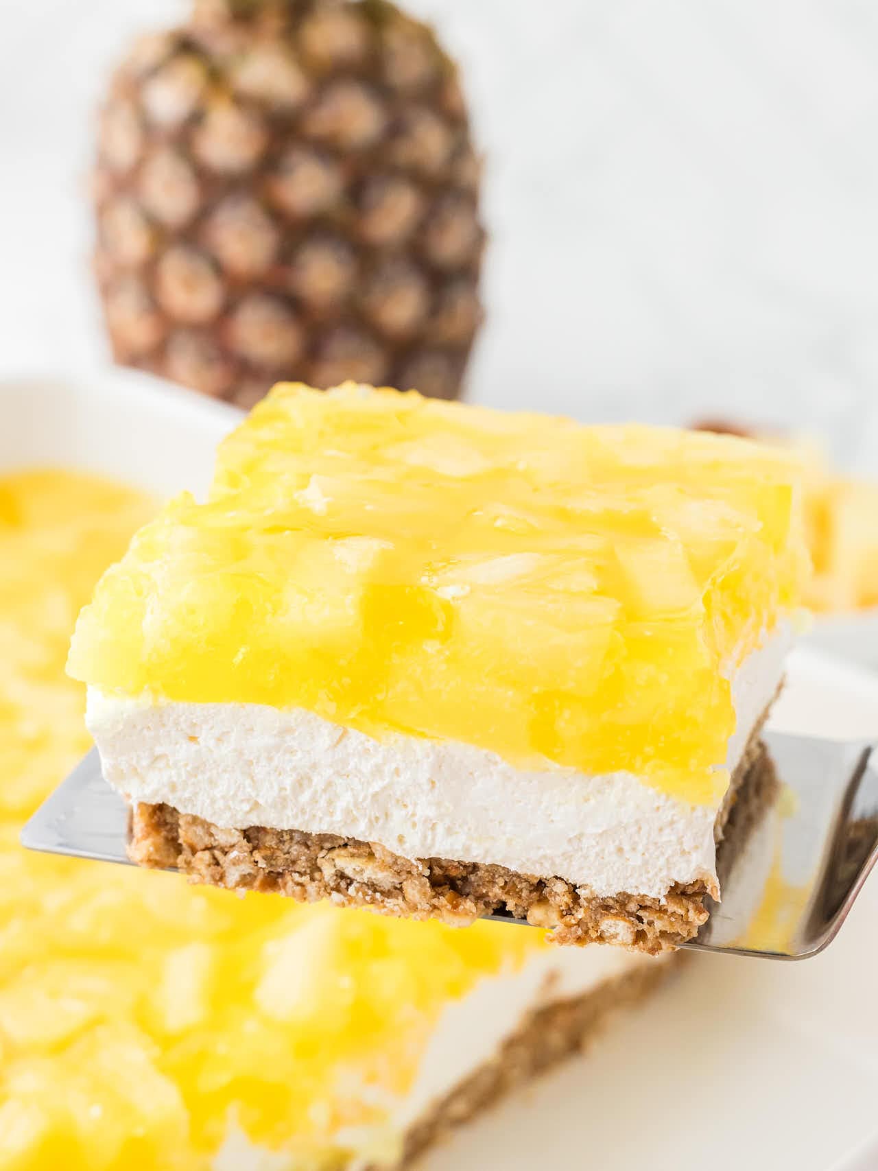 A slice of Pineapple Pretzel Salad on a spatula.