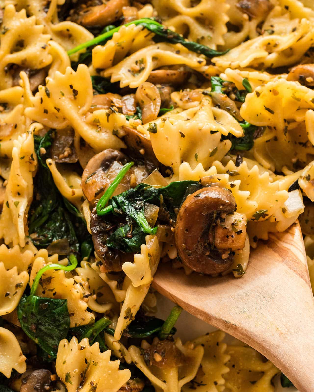 A wooden spoonful of Spinach Mushroom Pasta.