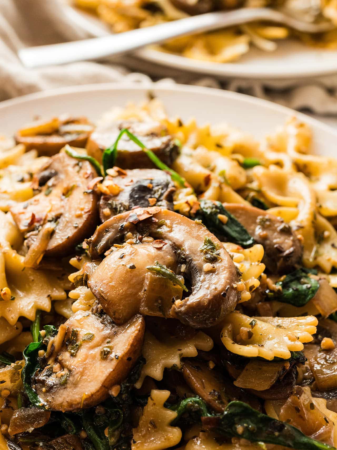 Plate of Spinach Mushroom Pasta, sautéed mushrooms, spinach in a light herb sauce.