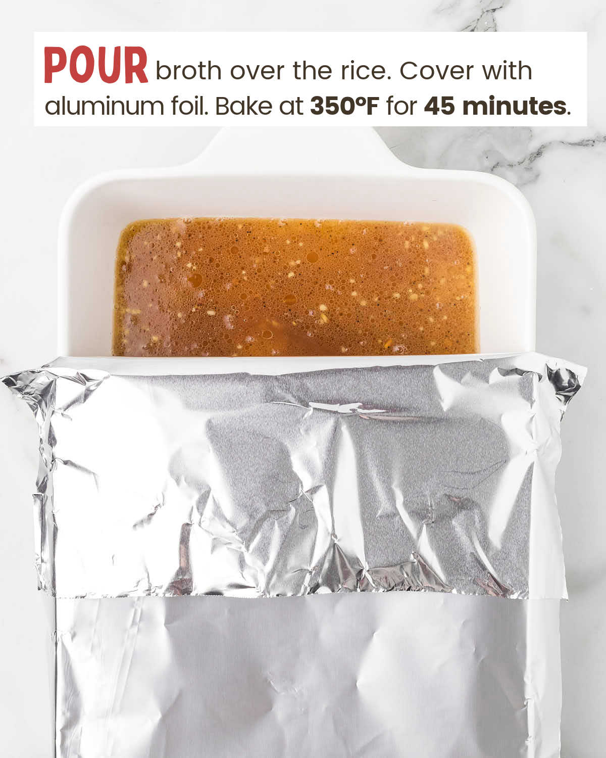 Aluminum foil partially covers a baking dish with broth over rice.