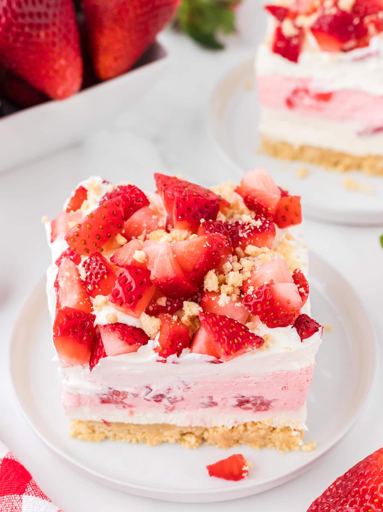 A slice of Strawberry Delight on a white plate. 
