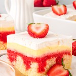A slice of Strawberry Poke Cake on a white plate.