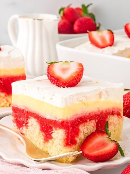 A slice of Strawberry Poke Cake on a white plate.