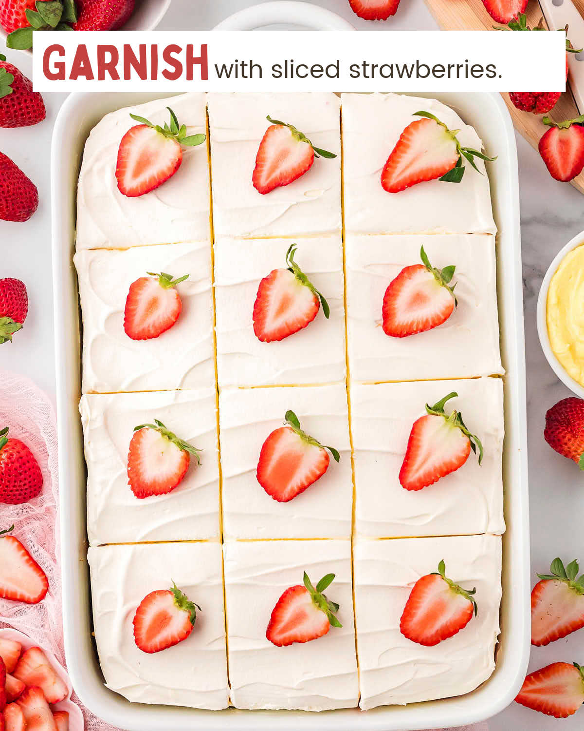 Strawberry poke cake garnished with strawberry slices.