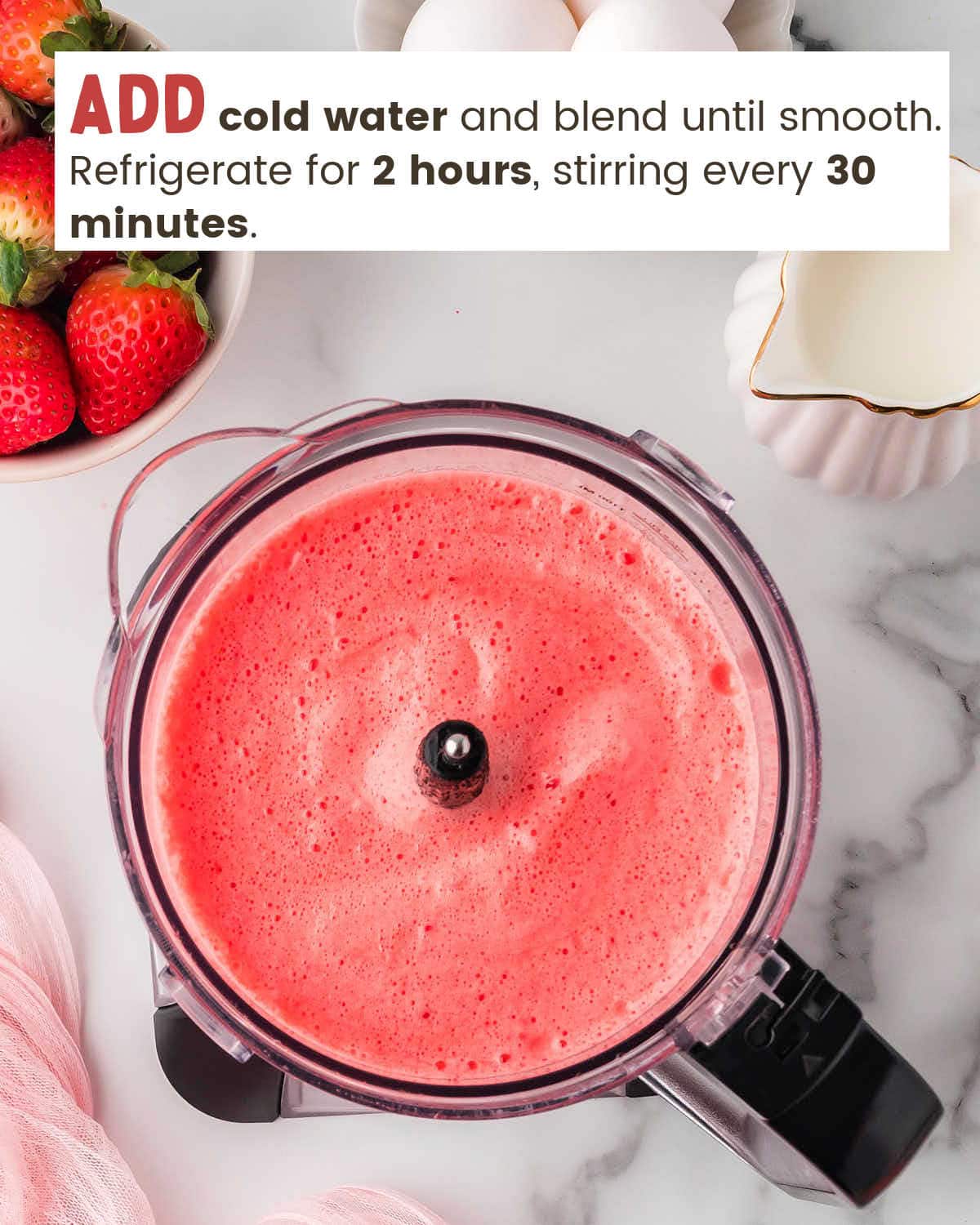 Top view of a strawberry Jello mixture in a blender.