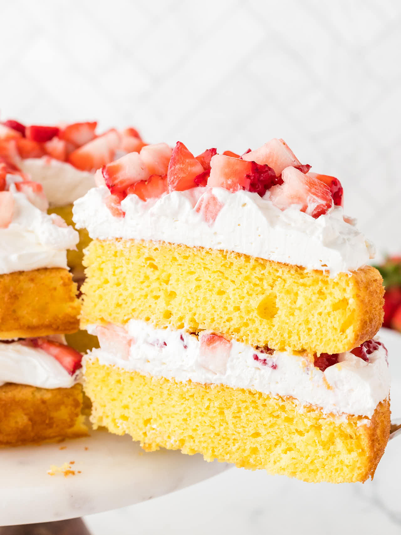 Lifting a slice of Strawberry Shortcake off the cake stand.