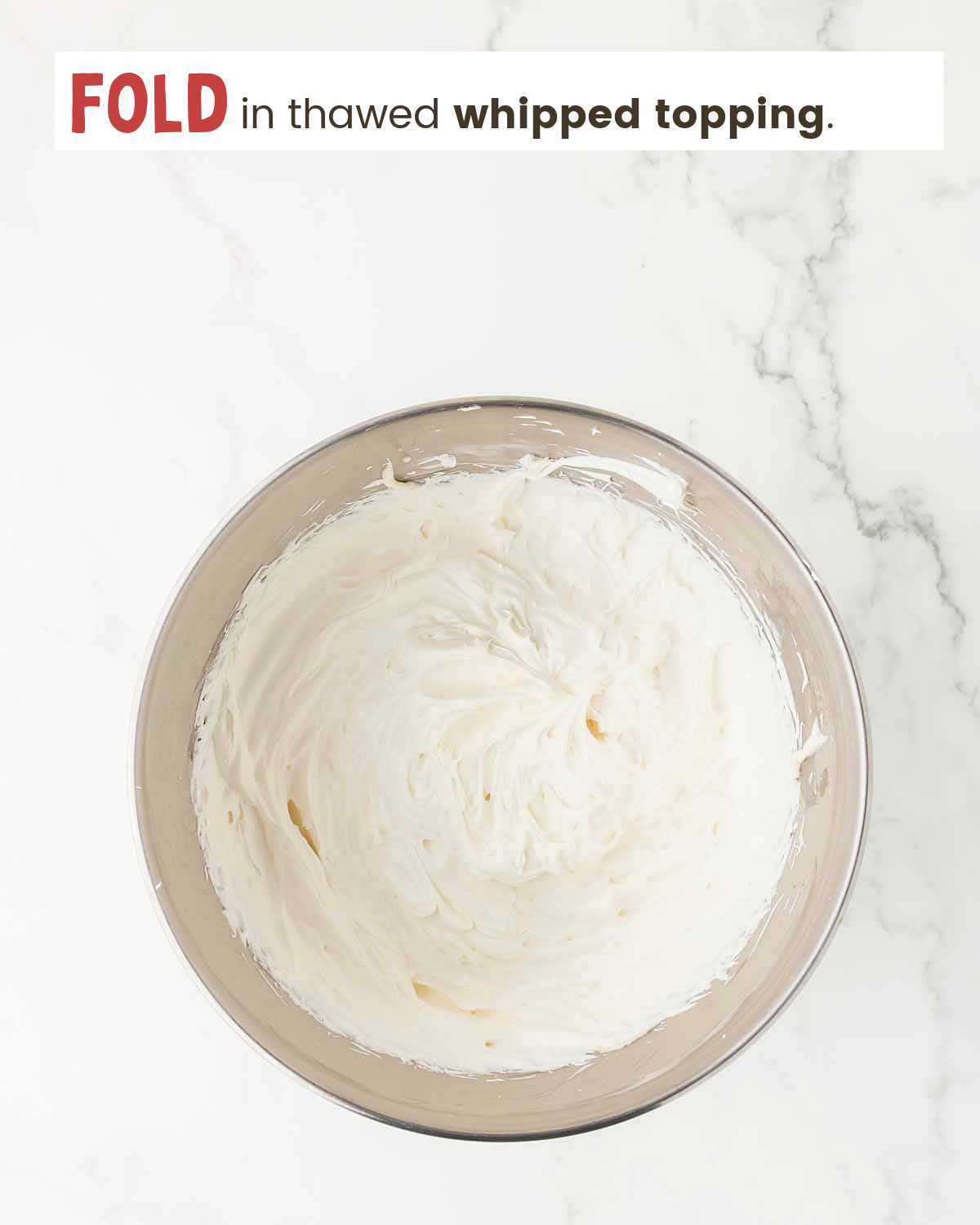 Cream cheese mixture in a mixing bowl with whipped topping folded in.