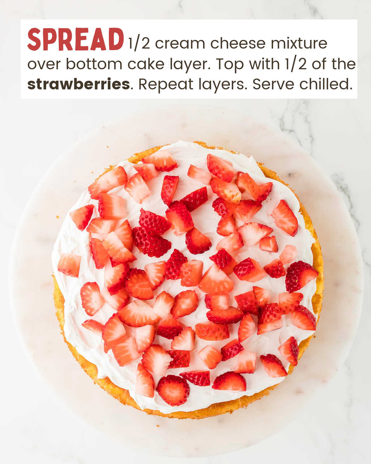 Overhead view of strawberry shortcake topped with chopped strawberries on a white platter.