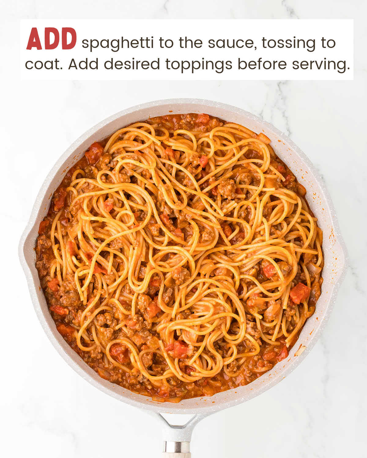 Spaghetti in a skillet covered with taco sauce.