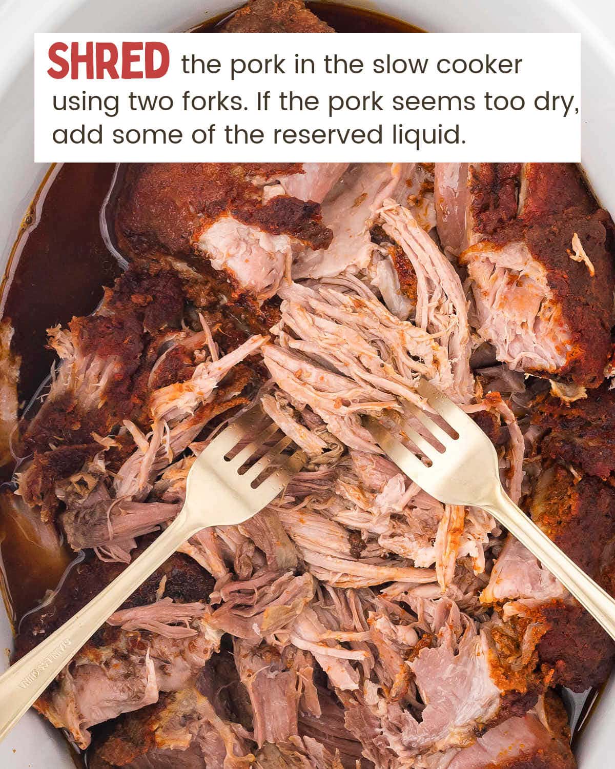 Pork shoulder in a Crock-Pot being shredded by two forks.
