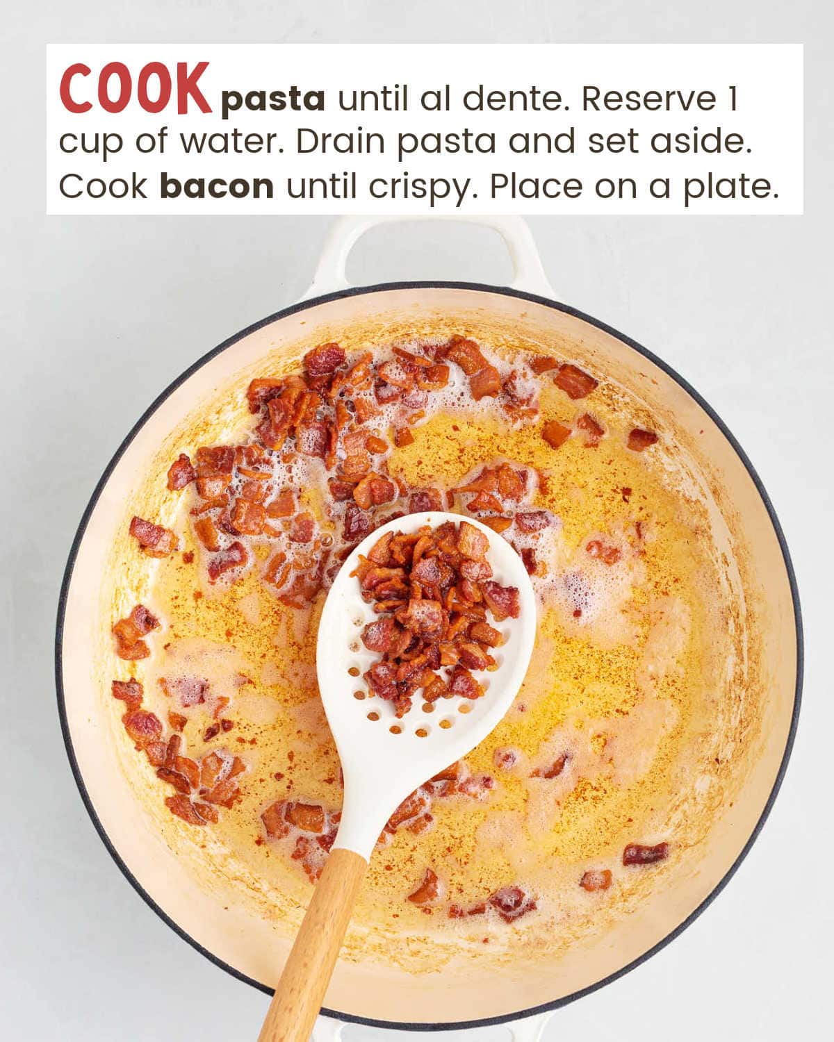 Chopped bacon in a pan with a spatula holding a scoop of it. 