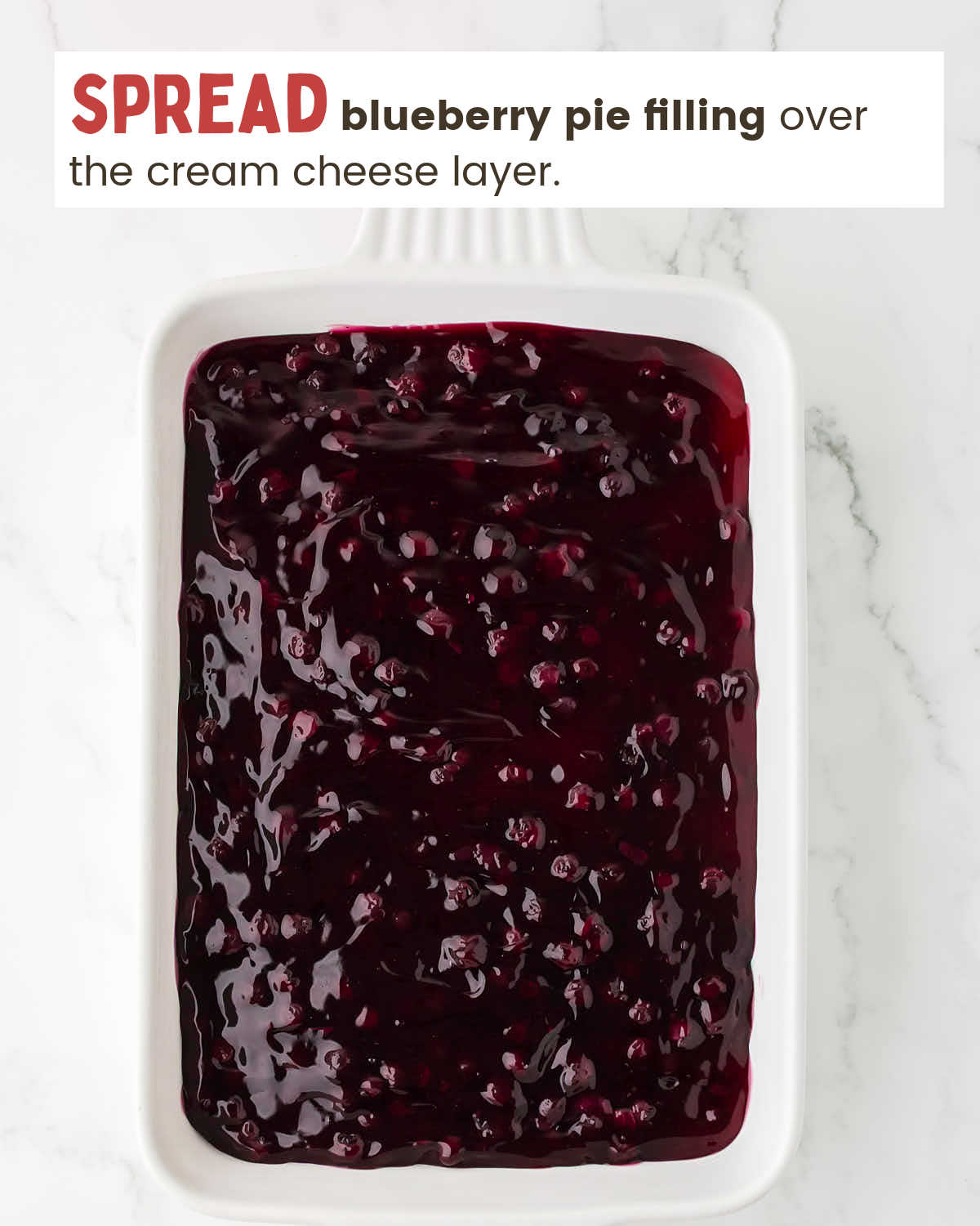 Blueberry pie filling layer in a baking dish.